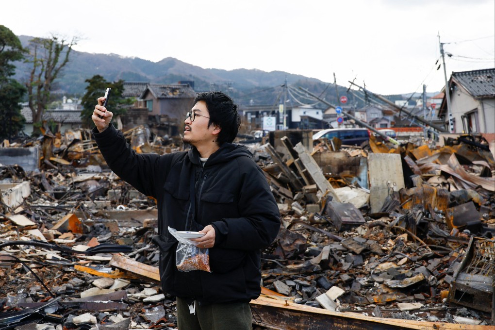 Japanese lacquer artist Kohei Kirimoto takes photos, while searching for his cats, next to an “Asaichi” morning market which burnt down in a quake-triggered fire, in Wajima, Japan, on Thursday. Photo: Reuters