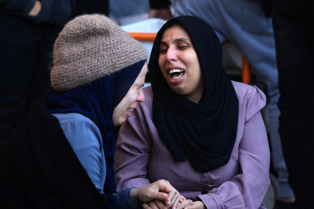 A woman (R) mourns her husband, killed when the tent they were sheltering in was hit by Israeli bombardment. Photo: AFP