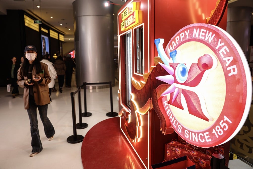 A woman wearing a face mask walks at a shopping mall past decorations for the celebration of 2024 New Year, in Beijing, China, 30 December 2023. Photo: EPA-EFE
