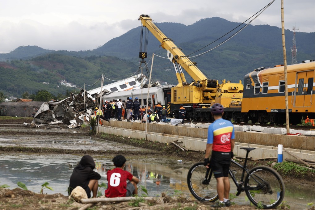 People watch as rescue workers search for victims in the wreckage of the collided passenger trains in Bandung. At least 22 people were injured when two trains carrying hundreds of passengers collided. Photo: EPA-EFE