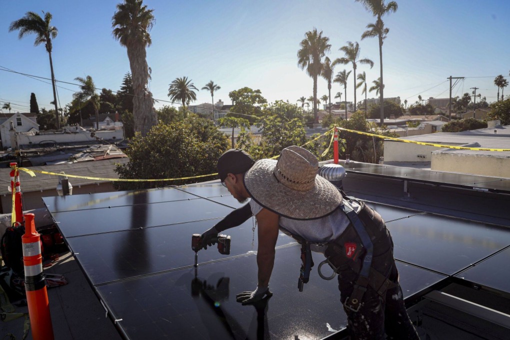 A worker installs solar panels on the rooftop of a home in Poway, California, on December 5. While green technology is billed as eco-friendly and energy-efficient, the replacement of items with electronic components only adds to the growing amount of e-waste. Photo: Bloomberg