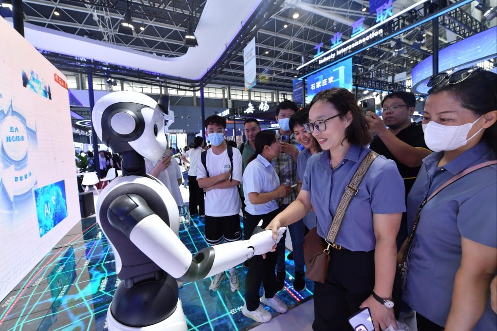 A visitor shakes hands with a humanoid robot during the China International Digital Economy Expo 2023 in Hebei Province. Photo: Xinhua