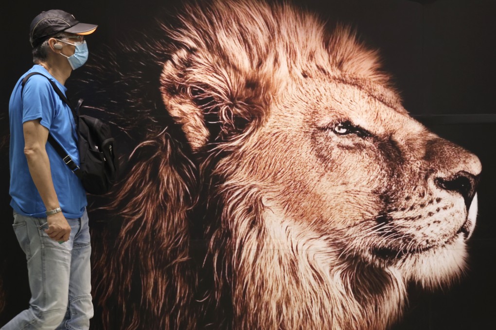 A commuter walks past an advertisement for China Asset Management, at Central MTR station. Photo: Jonathan Wong