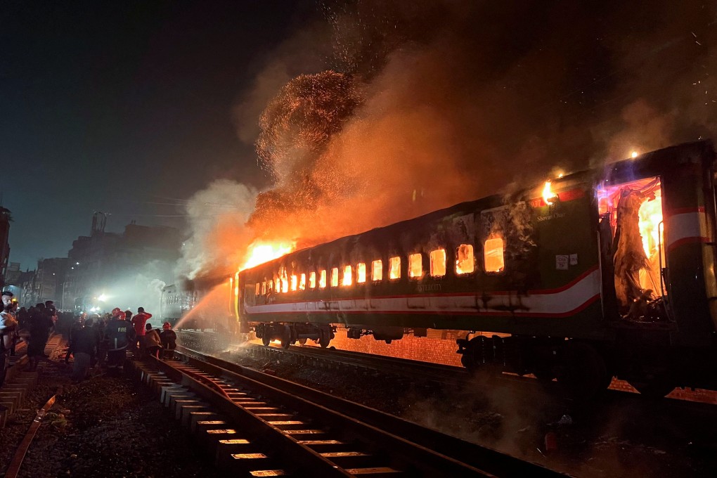 Firefighters attempt to extinguish a fire on a passenger train in Dhaka, Bangladesh on Friday. Photo: Reuters