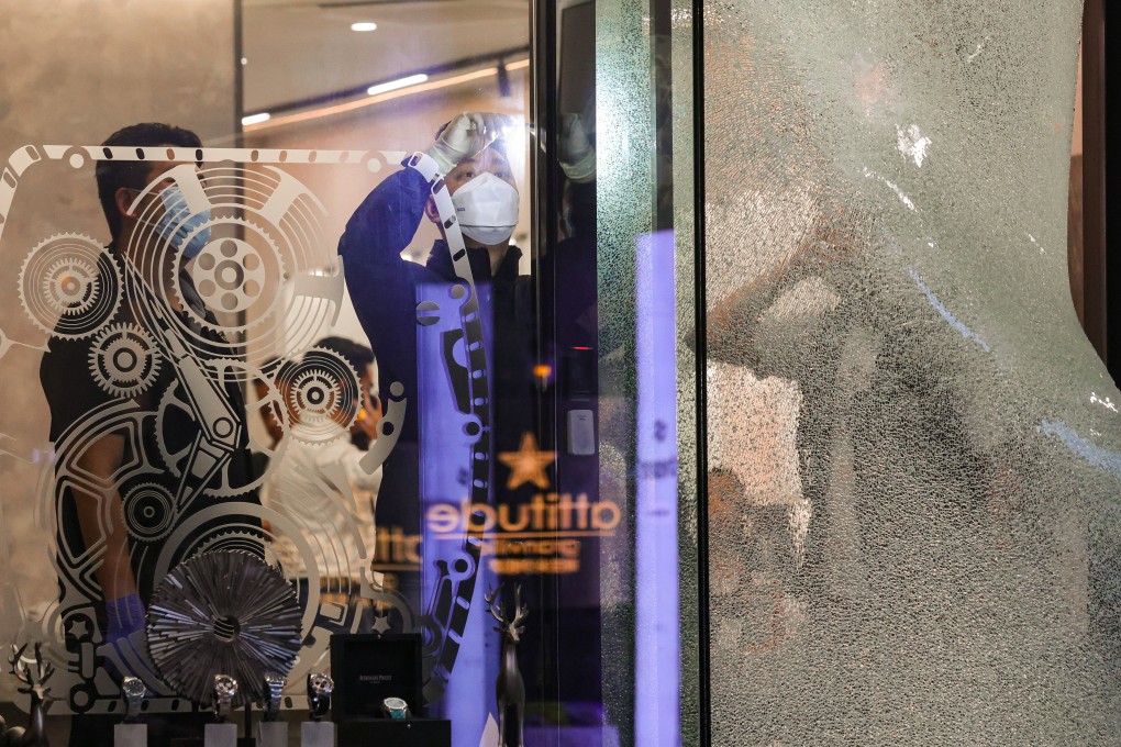 Officers gather evidence at the store. Two of the suspects smashed a display counter with two sledgehammers before they fled with 24 watches. Photo: May Tse
