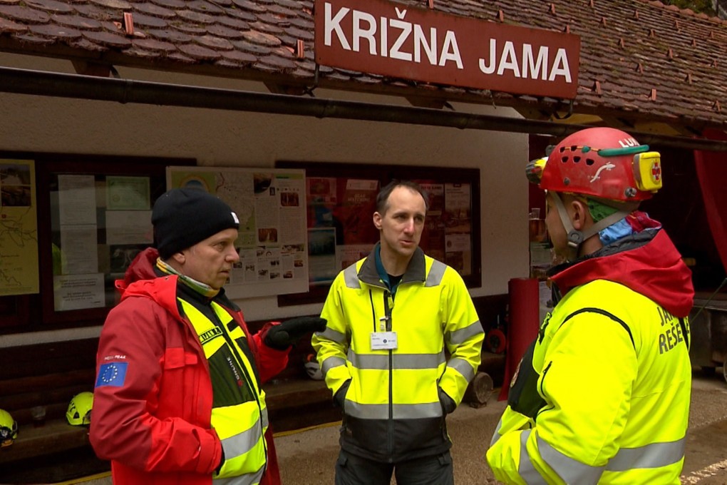 Rescuers gather outside the Krizna Jama cave near Grahovo, Slovenia on Sunday. Photo: Pop TV via AP
