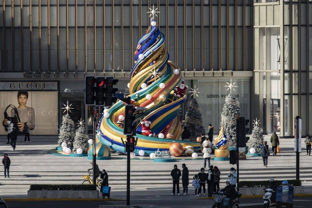 Shoppers walk past a Christmas-themed decoration outside an upscale shopping centre in Shanghai on December 17. Chinese regulators recently broadened the scope of the real estate investment trust programme to include shopping centres, offering a fresh option to property investors in search of improved returns. Photo: Bloomberg