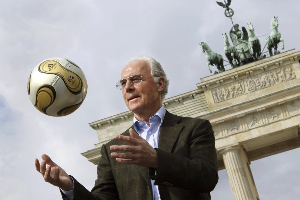 Franz Beckenbauer presents the golden football for the 2006 World Cup final in front of the Brandenburg Gate in Berlin, Germany in April 2006. Photo: dpa via AP