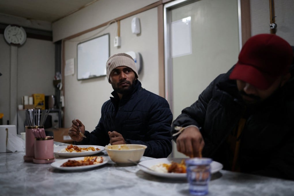Sri Lankan workers Siyam Mohamed, 25, and MJ. Nimshan Dananjaya, 23, eat lunch on South Korea’s Yeonpyeong Island on Tuesday. Photo: Reuters