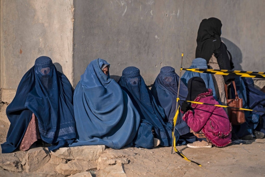 Afghan burqa-clad women sit as they wait to receive aid from the World Food Programme organisation in Pul-i-Alam, Afghanistan, on January 7. Photo: AFP