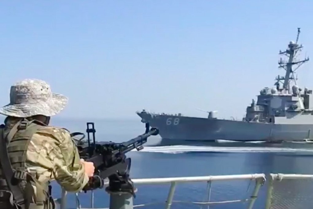 An Iranian soldier on a jet boat in front of a US warship during the seizure of a Vietnam-flagged oil tanker in the Gulf of Oman in November 2021. Photo: EPA-EFE