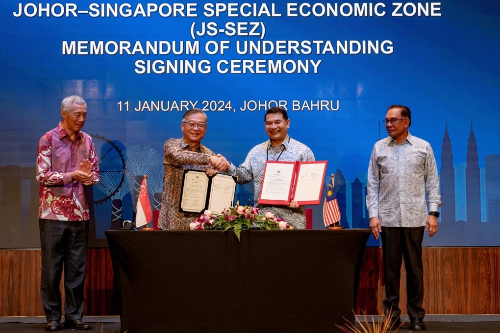 Lee Hsien Loong and Anwar Ibrahim look on as Singapore’s trade and industry minister, Gan Kim Yong (centre, left), and Malaysia’s economy minister, Mohd Rafizi Ramli (centre, right), shake hands after a signing ceremony in Johor Bahru on Thursday. Photo: Reuters