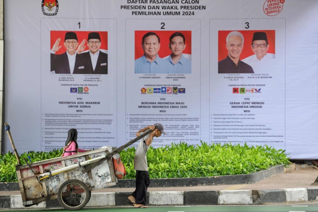 A man in Jakarta pulls a cart past posters listing three pairs of candidates for the Indonesian election. Photo: AFP