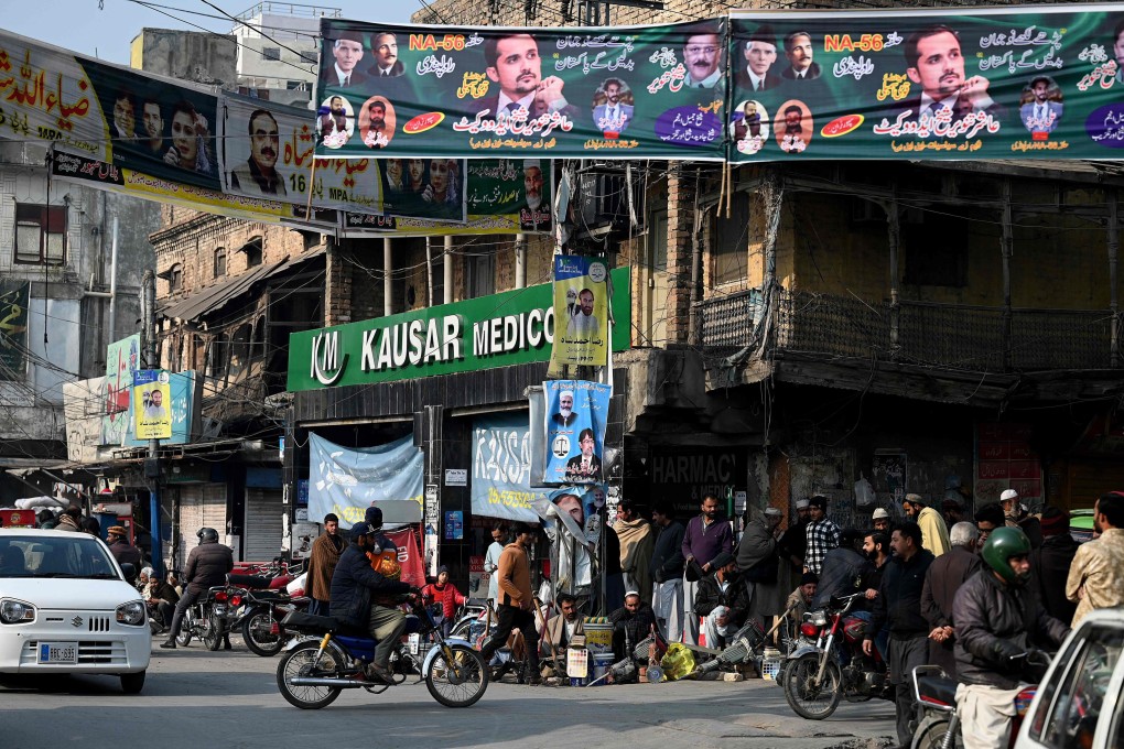 Commuters move past election campaign posters along a road in Rawalpindi on Tuesday, ahead of Pakistan’s general election on February 8. Photo: AFP