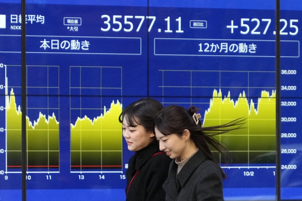 People walk past a Tokyo stock market indicator board in Japan on Friday. The Tokyo stock market continued to rise sharply to end the week at 35,577.11 yen, up 527.25 yen, its highest figure in about 34 years. Photo: EPA-EFE