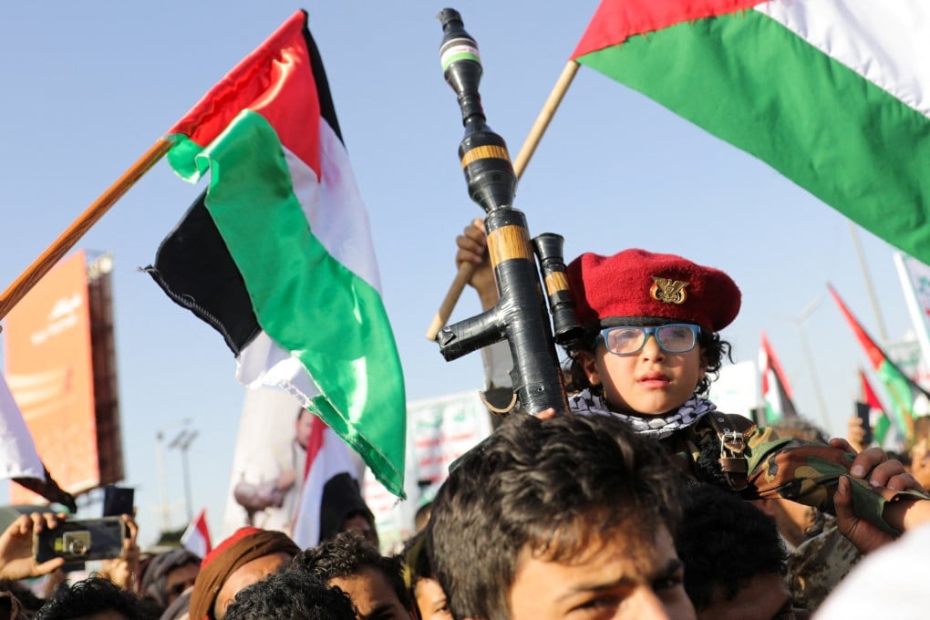 A child holds a mock RPG (rocket propelled grenade launcher), as supporters of the Houthi movement rally to denounce air strikes launched by the US and Britain in Sanaa, Yemen on Friday. Photo: Reuters