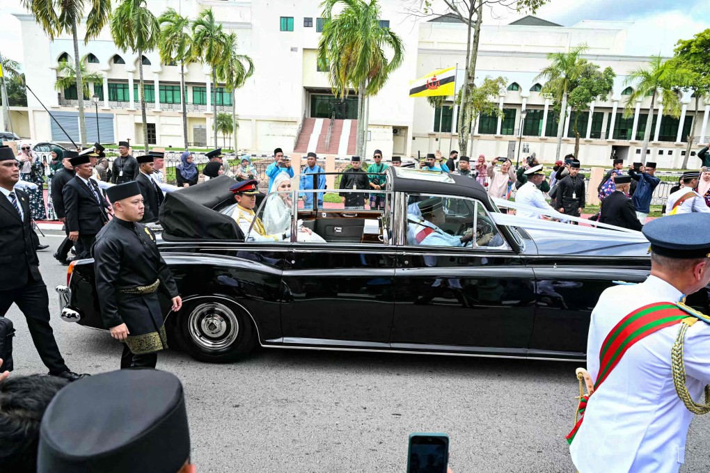 Brunei’s Prince Abdul Mateen and Anisha Rosnah wave from their car during the wedding procession in Bandar Seri Begawan on Sunday. Photo: AFP