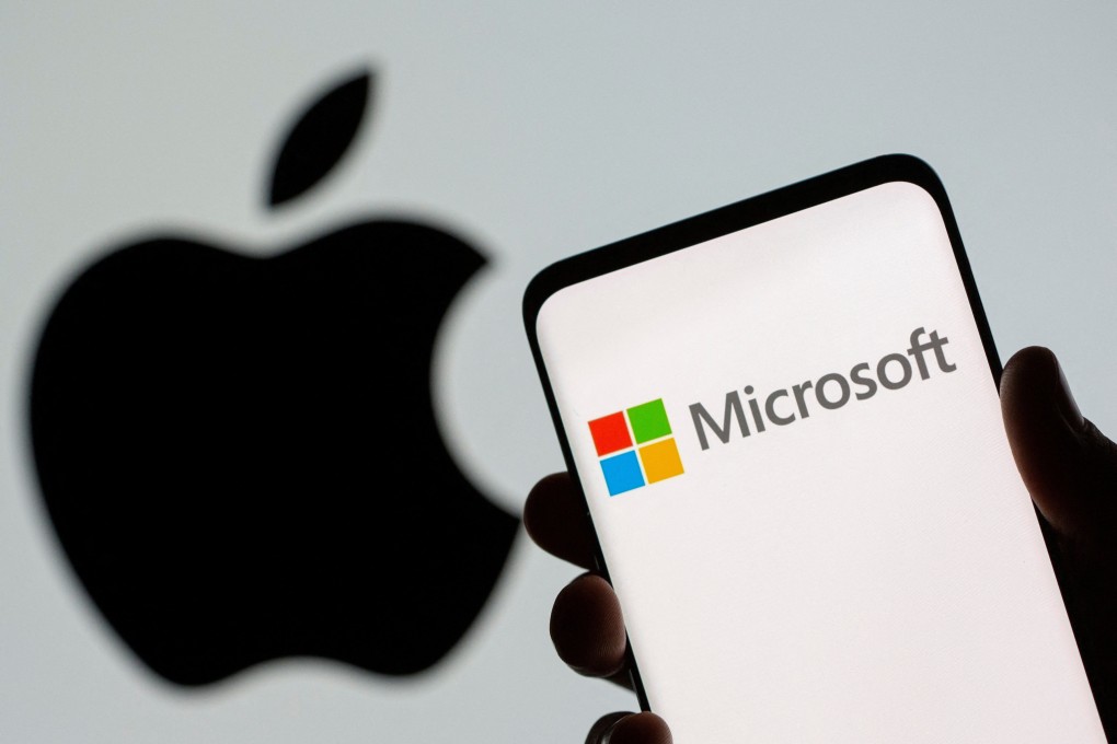 Microsoft’s logo is seen on a smartphone in front of Apple’s logo in an illustration. Photo: Reuters