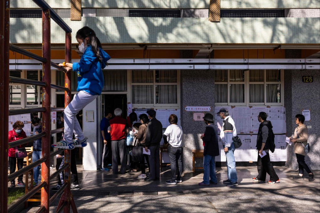 A child plays as people wait in line to cast their ballots in the presidential election in New Taipei on January 13. Photo: AFP
