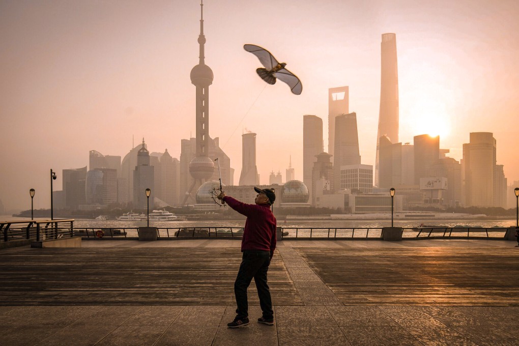 A person flies a kite on the Bund in front of buildings in Pudong’s Lujiazui Financial District in Shanghai on January 9, 2024. Photo: Bloomberg