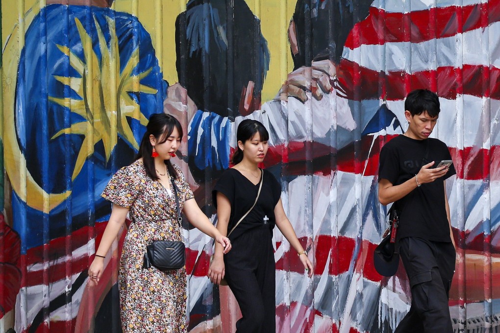People walk past a mural featuring the Malaysian flag in Kuala Lumpur. Malaysia is eyeing regional leadership in cloud computing, machine learning and as a gateway for global tech start-ups. Photo: EPA-EFE