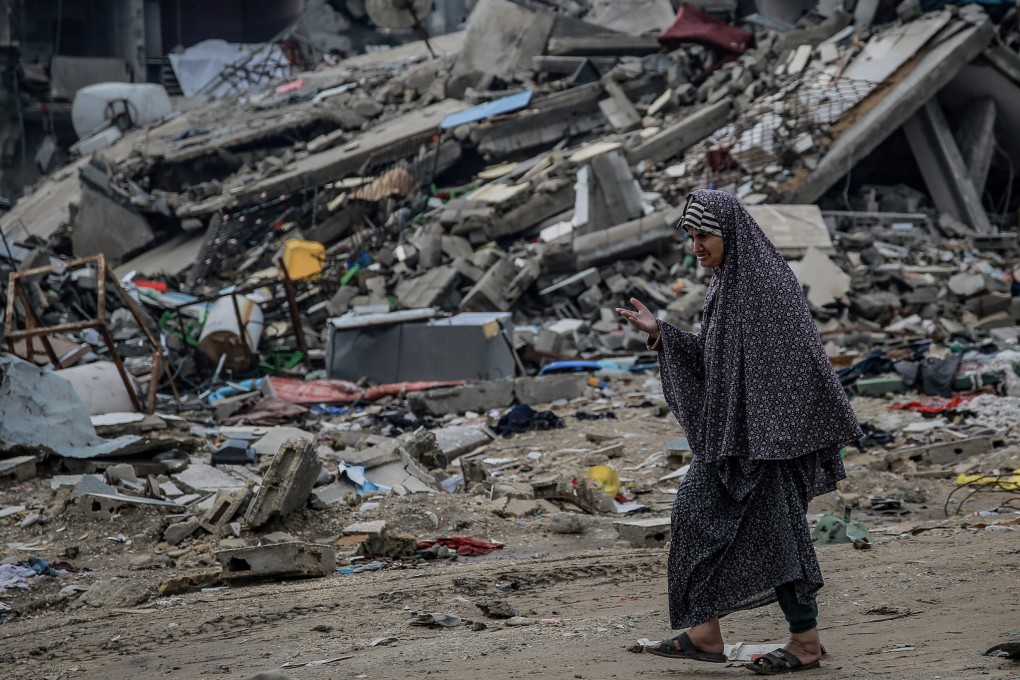 A Palestinian woman walks past destroyed buildings in the Sheikh Radwan neighbourhood. Photo: dpa