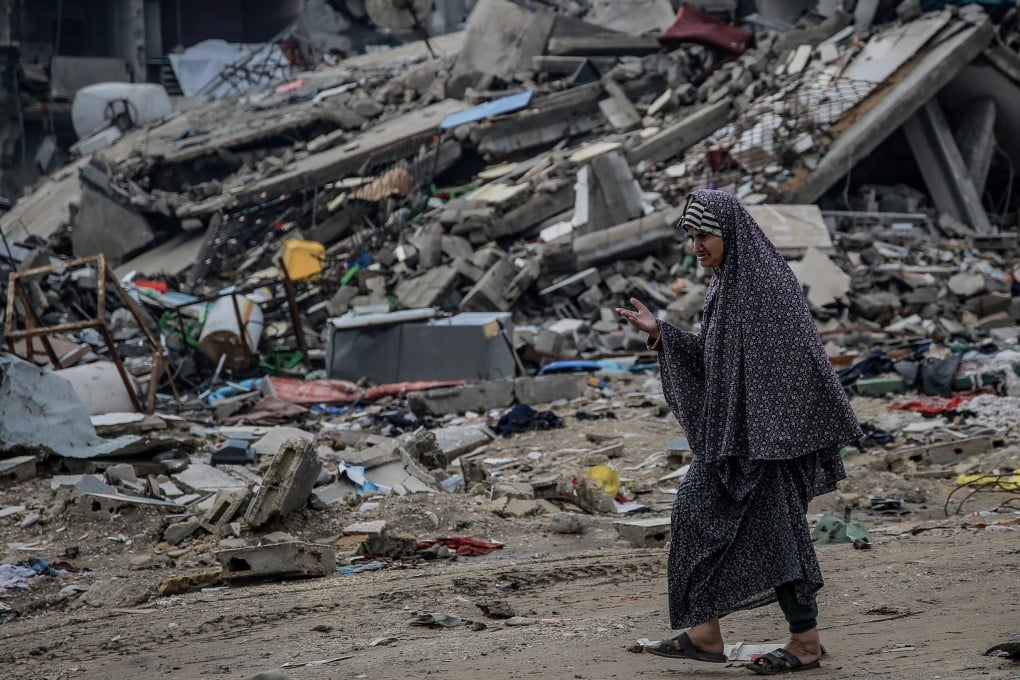 A Palestinian woman walks past destroyed buildings in the Sheikh Radwan neighbourhood. Photo: dpa