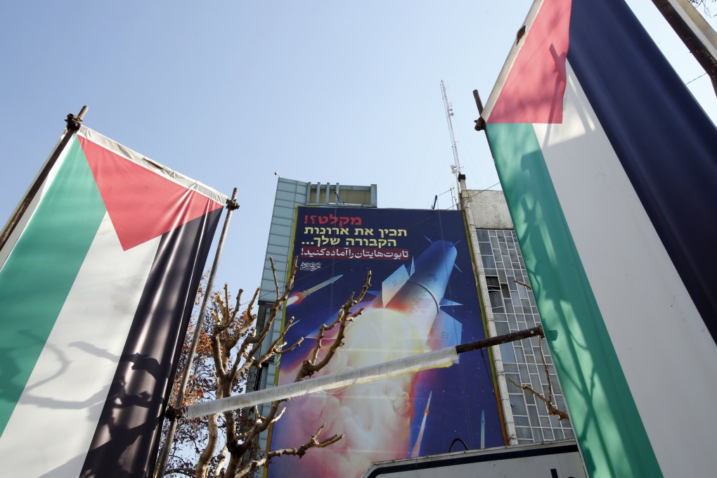 Palestinian flags and a billboard depicting Iranian missiles are seen in Tehran, Iran on Tuesday with a message in Persian and Hebrew reading: “Prepare your coffins”. Photo: EPA-EFE