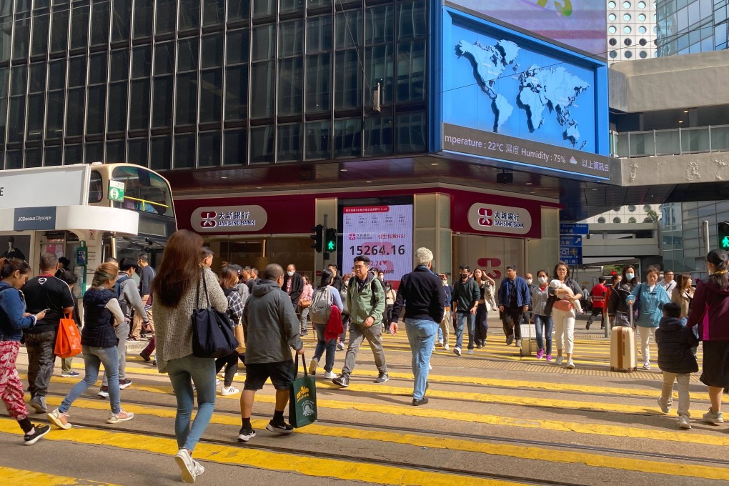 People crossing a busy street near a bank branch in Central, Hong Kong on January 18, 2024. Photo: Li Jiaxing