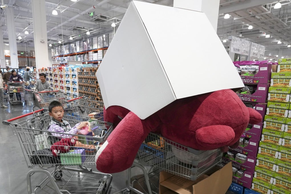 A boy sits in a trolley next to a giant Lotso stuffed toy at the newly opened Costco in Shenzhen on January 13. The American retail chain is just the latest shopping attraction to lure Hongkongers across the border. Photo: Eugene Lee