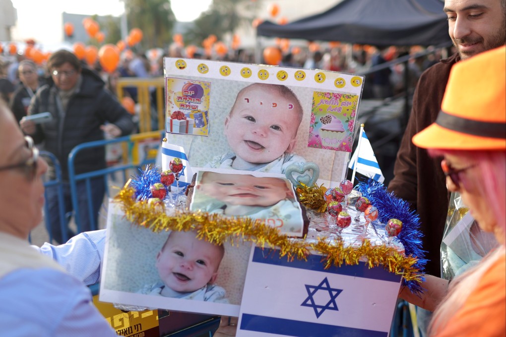 People hold a birthday cake to mark the first birthday of Israeli toddler Kfir Bibas, who is held hostage by Hamas in Gaza, outside the Kirya military base in Tel Aviv, Israel on Thursday. Photo: EPA-EFE