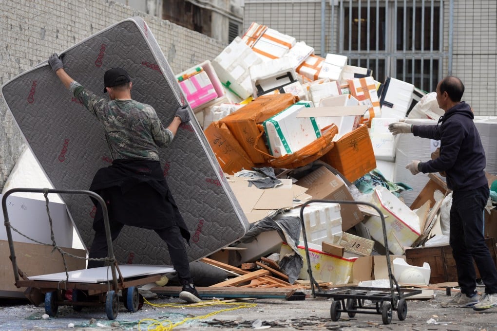 Workers handle waste at a collection point. The scheme was earlier delayed because of concerns over a staff shortage. Photo: Eugene Lee