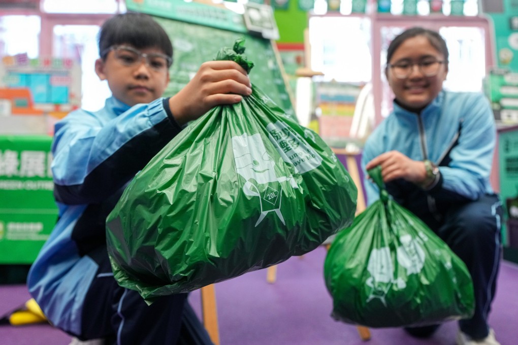 Students display designated bags for the waste-charging scheme at a promotional event earlier this week. Photo: Eugene Lee