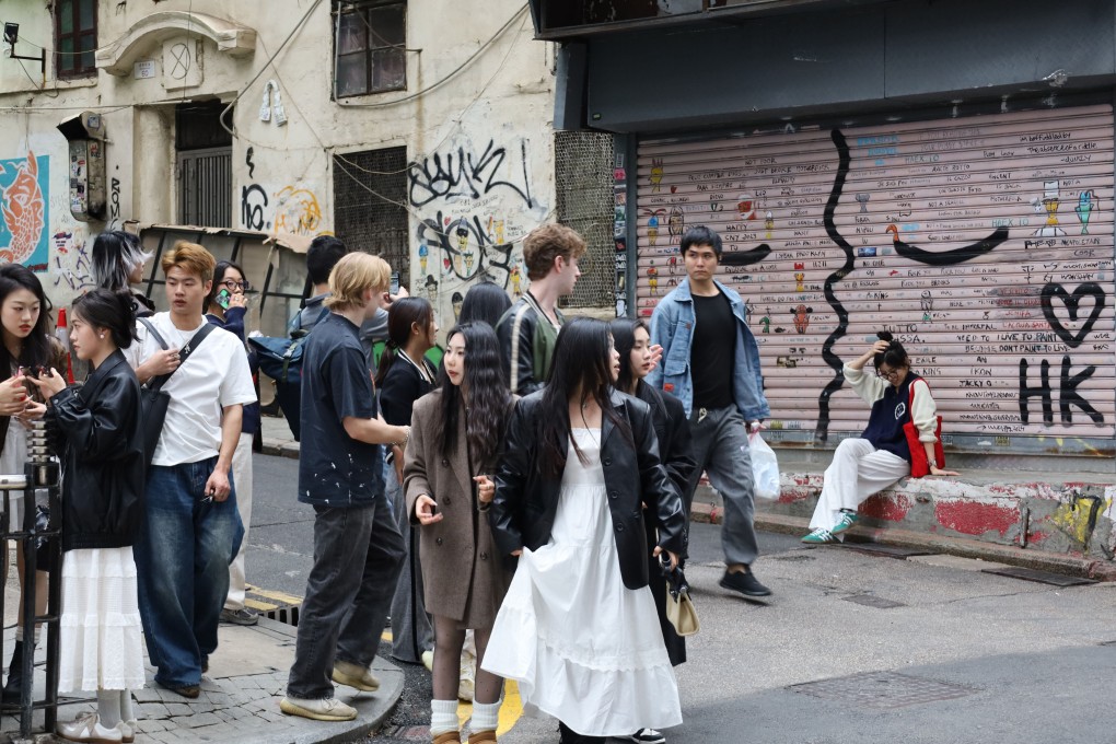 Tourists post for photos in front of graffiti on Central’s Peel Street. Photo: Wynna Wong