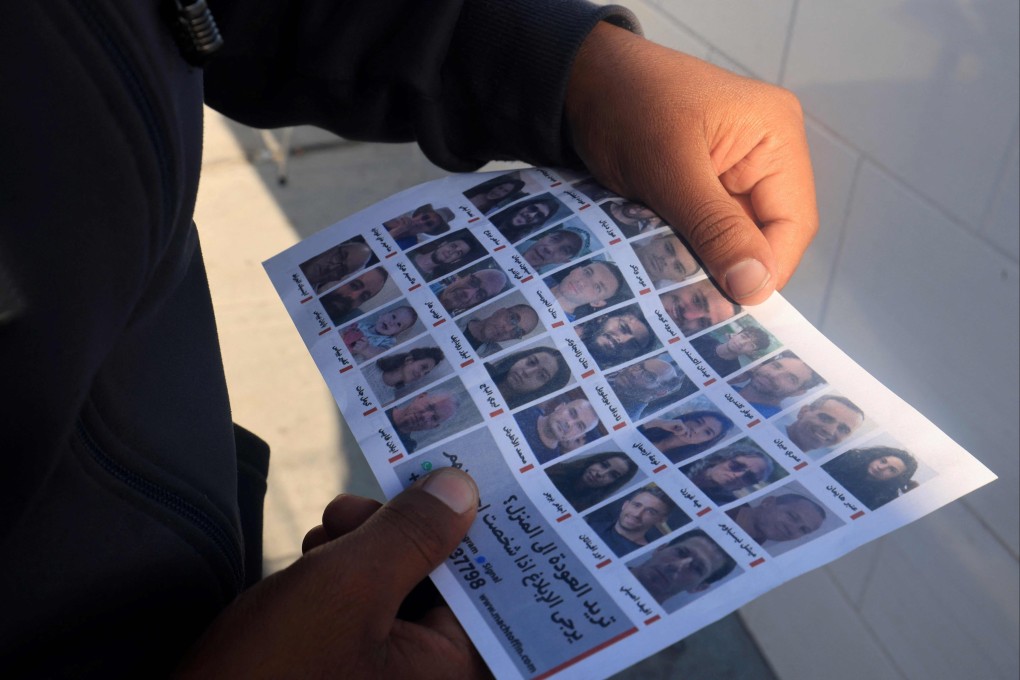 A man on Tuesday holds one of the leaflets dropped by Israeli forces over Rafah showing portraits of hostages held in Gaza. Photo: AFP