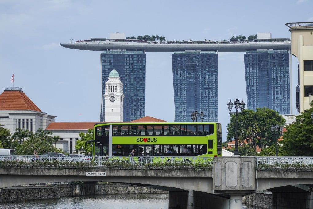 A public bus passes a bridge in Clarke Quay in front of the Marina Bay Sands Hotel in Singapore. SimplyGo was introduced in 2019 by LTA to offer a range of digital ticketing and e-payment options for transit. The system allows cardholders to view fare history and top-up card balance on-the-go via a mobile application. Photo: Roy Issa