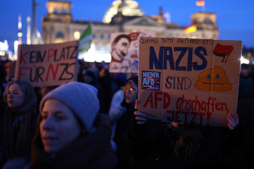 A protester holds up a placard during a demonstration against racism and far right politics in front of the Reichstag building in Berlin, Germany on Sunday. Photo: AFP