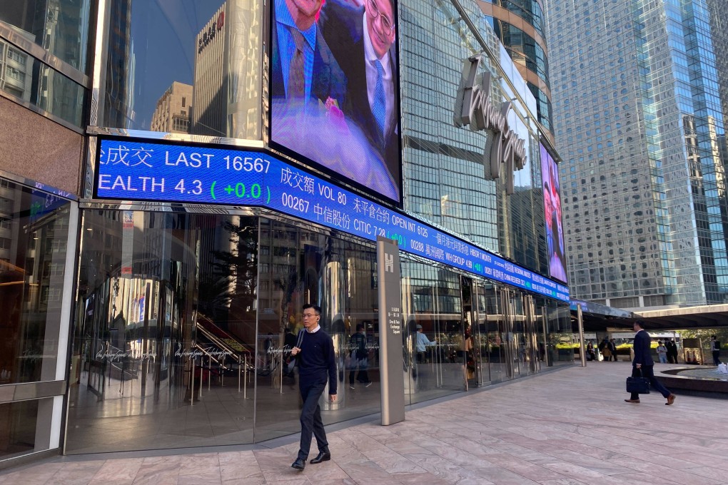 People walking outside the Exchange Square in Central, Hong Kong with tickers showing stock prices on December 7, 2023. Photo: Li Jiaxing