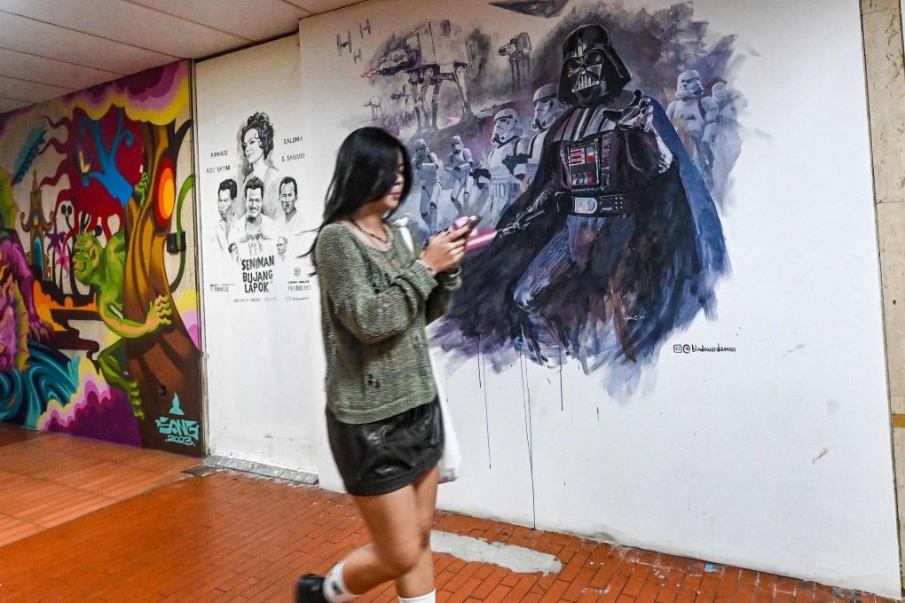 A woman walks past murals at the Peace Centre, an abandoned mall turned into an unexpected art enclave, in Singapore. Photo: AFP