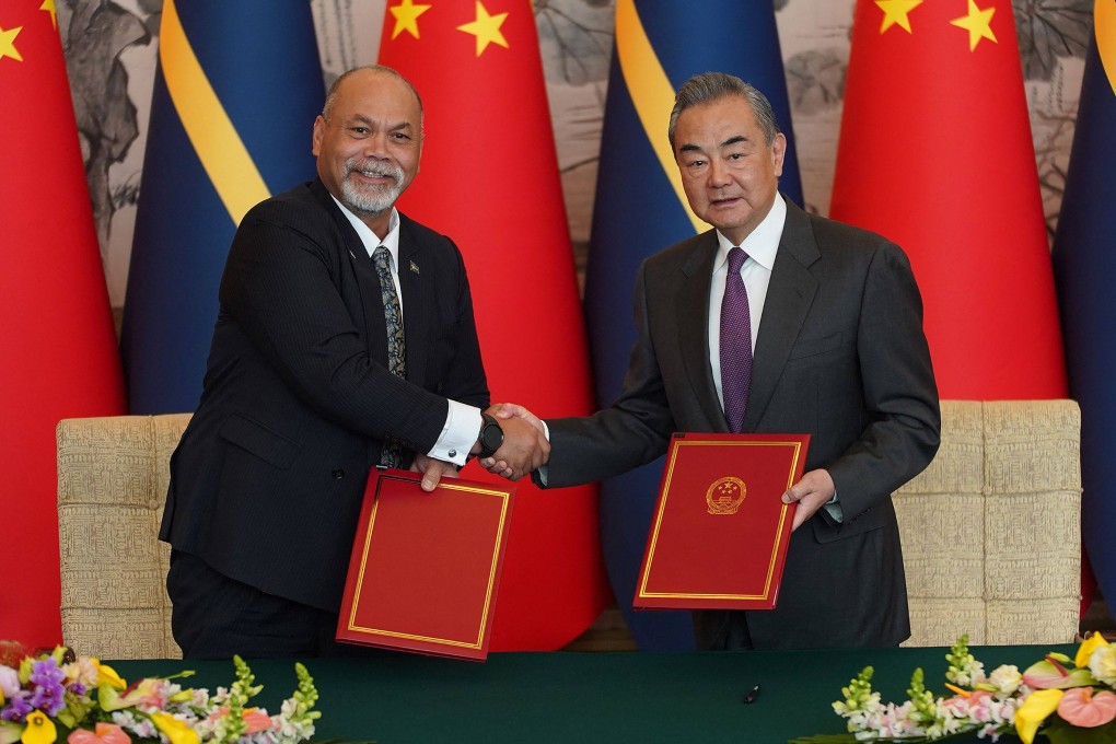 Nauru’s foreign minister Lionel Aingimea, left, shakes hands with China’s Foreign Minister Wang Yi after signing the joint communiqué on the resumption of diplomatic relations. Photo: AFP