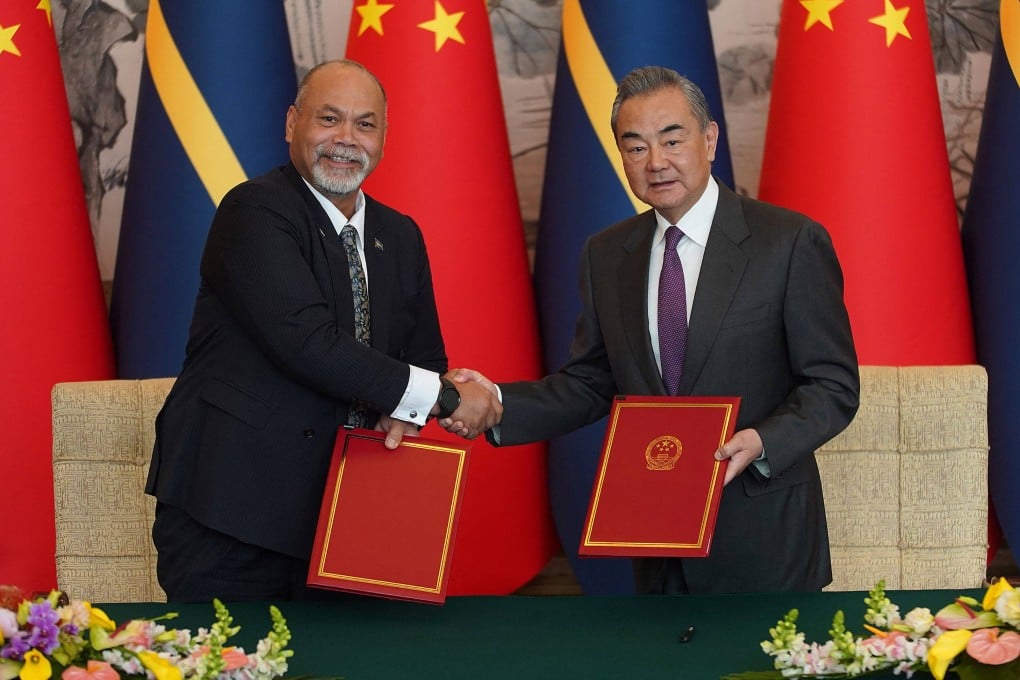 Nauru’s foreign minister Lionel Aingimea, left, shakes hands with China’s Foreign Minister Wang Yi after signing the joint communiqué on the resumption of diplomatic relations. Photo: AFP