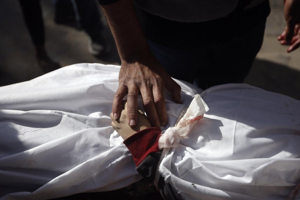 A Palestinian man mourns over the body of a child killed in the Israeli bombardment of the Gaza Strip, at Nasser hospital in Khan Younis, on Monday. Photo: AP