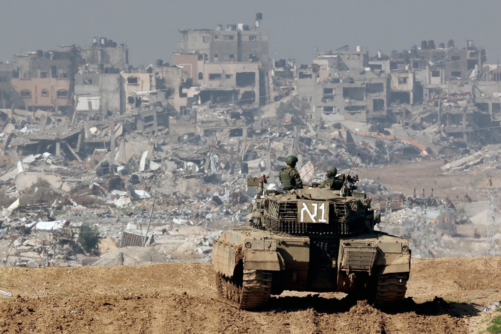 An Israeli tank and damaged buildings in the Gaza Strip in the background. Photo: AFP