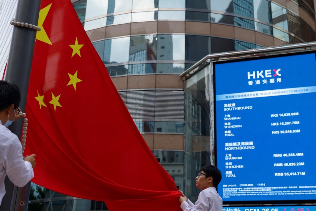 The Chinese national flag in front of screens showing the index and stock prices outside Exchange Square in Central, Hong Kong. Photo: Reuters