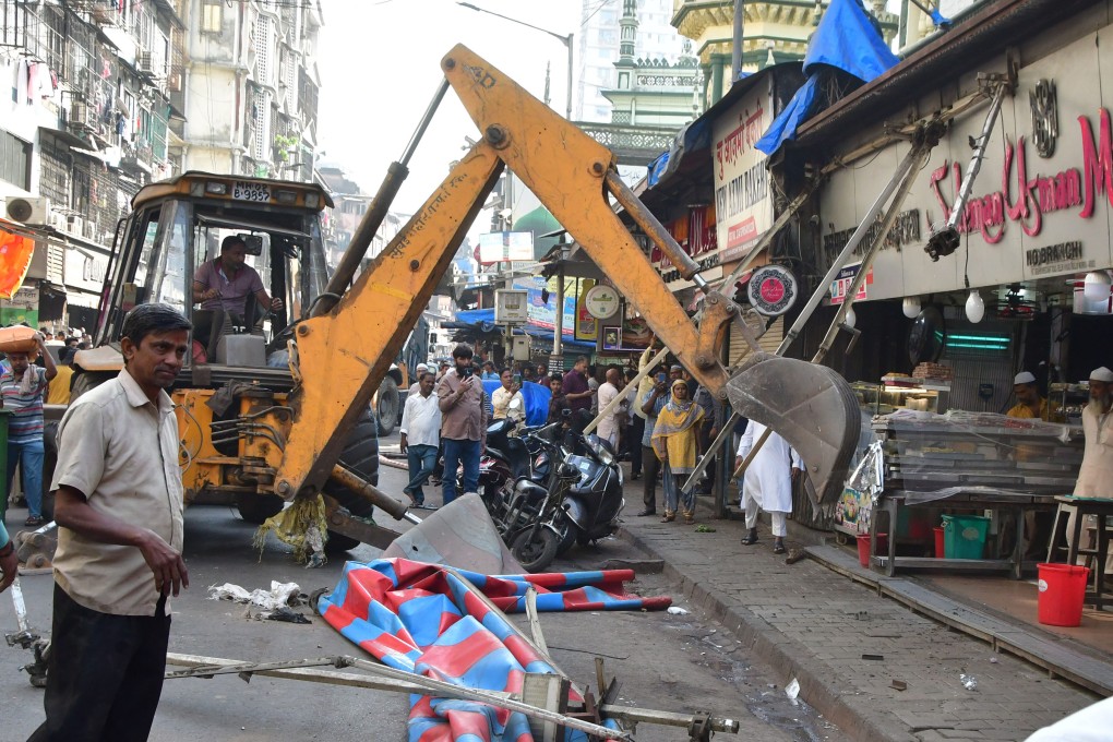 A bulldozer demolishes illegal structures that were obstructing the construction, at Mohammed Ali Road in Mumbai on Wednesday. Photo: Getty Images