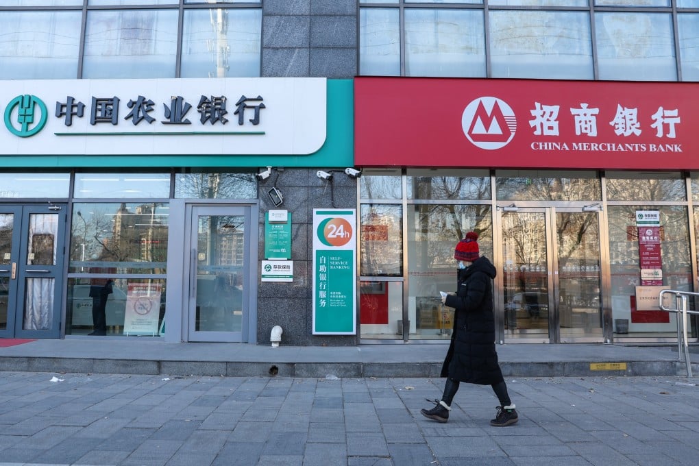 A woman walks beside a bank in Beijing. Photo: EPA-EFE
