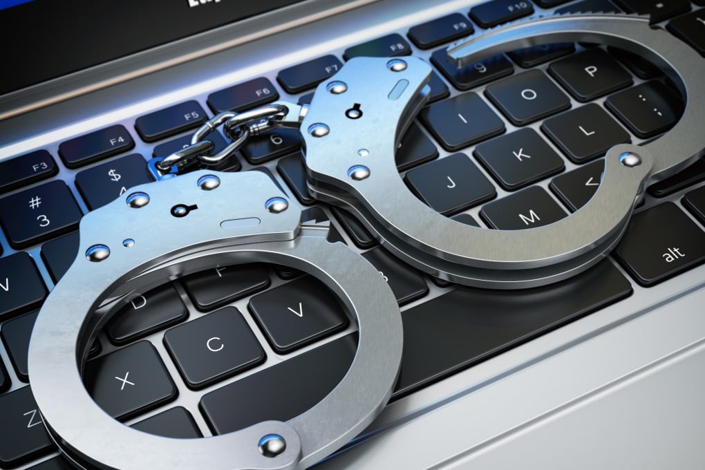 Handcuffs on a laptop keyboard. Photo: Shutterstock