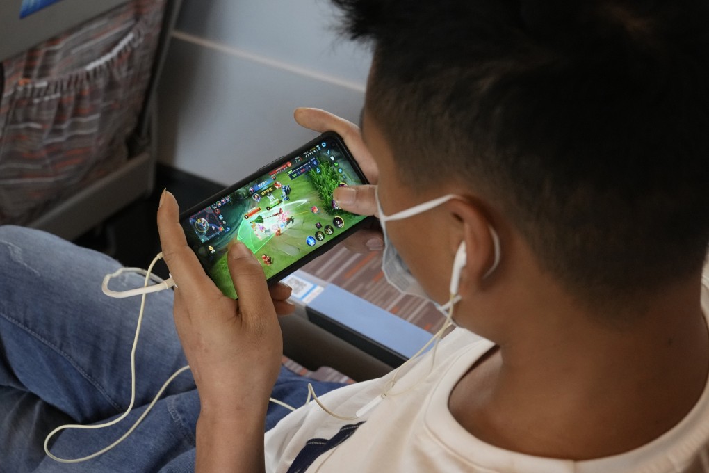 A man plays an online game developed by Chinese tech giant Tencent on a train from Henan to Beijing on September 15, 2021. Photo: AP