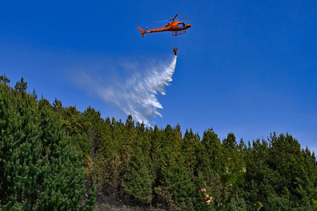 A helicopter drops water to put out a forest fire in Nemocon, Colombia, on Friday. The nation has asked the United Nations for help. Photo: AFP