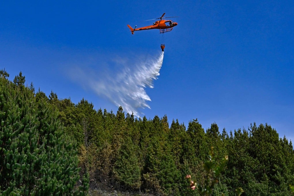 A helicopter drops water to put out a forest fire in Nemocon, Colombia, on Friday. The nation has asked the United Nations for help. Photo: AFP